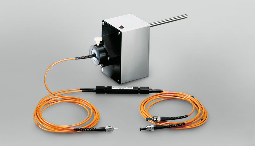 Fiber optic coupler consisting of a central beam splitter (black elongated central part) and four multi-mode optical fibers (orange lines) with ST (straight tip) connectors. Grey box: Photomultiplier.
