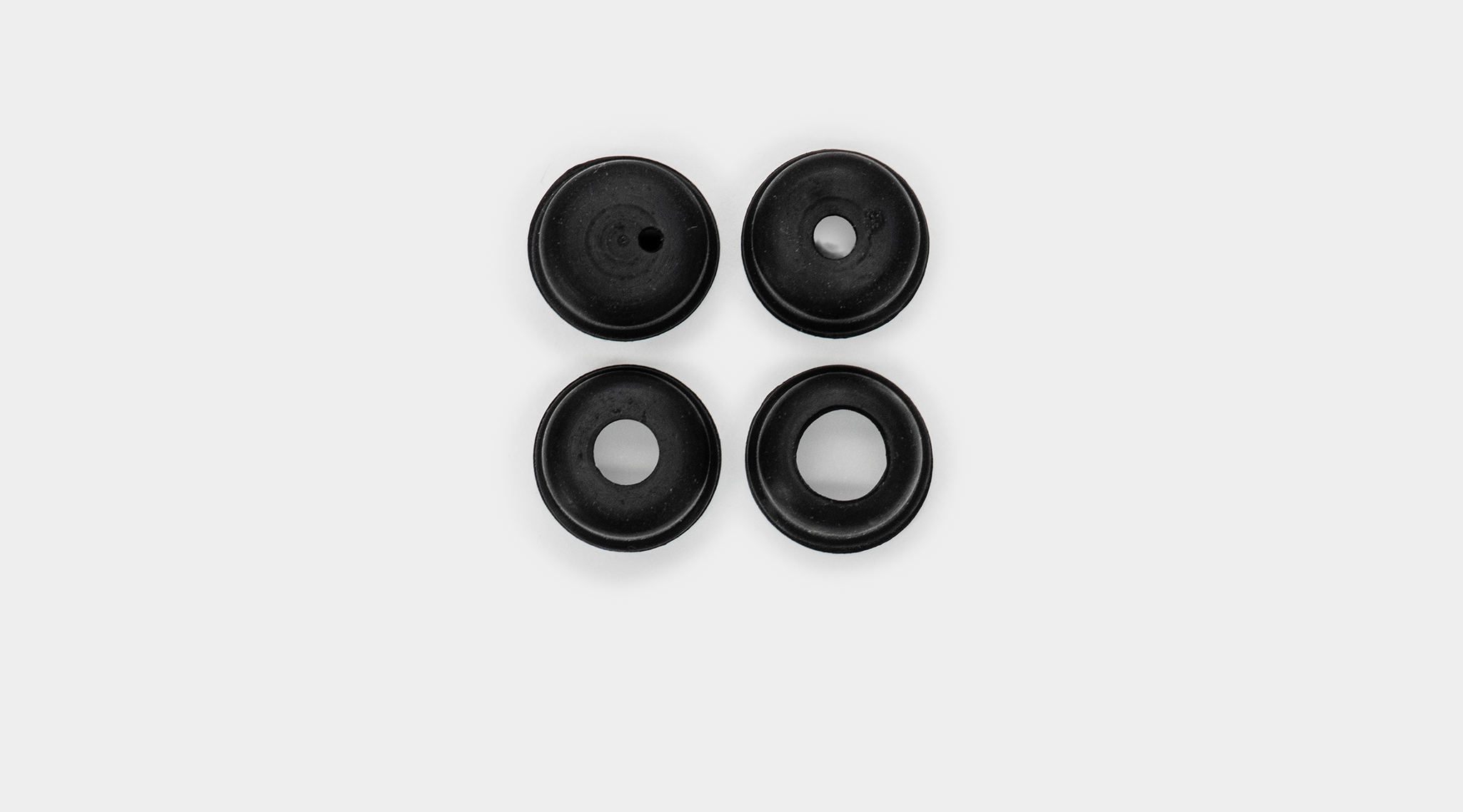 DUAL-OP optical pinhole set showing four black cylindrical pinhole adapter in different sizes